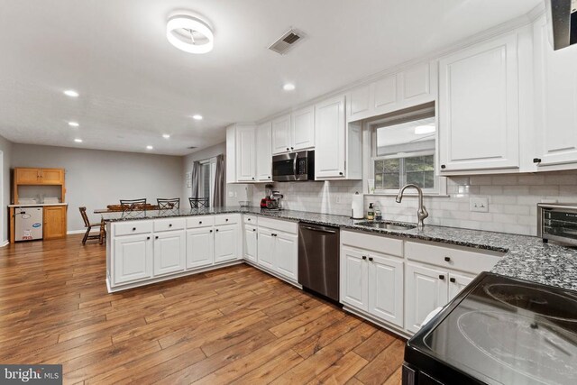 kitchen with white cabinetry, stainless steel appliances, and light hardwood / wood-style floors