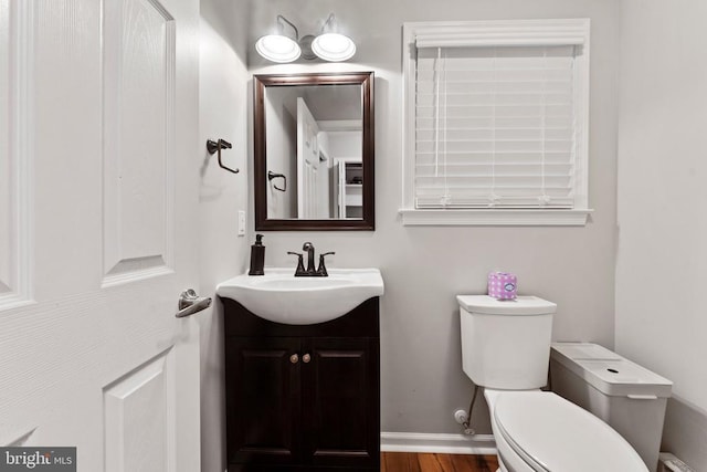 bathroom with vanity, toilet, and wood-type flooring