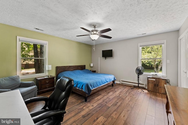 bedroom with a baseboard radiator, a textured ceiling, ceiling fan, and hardwood / wood-style floors