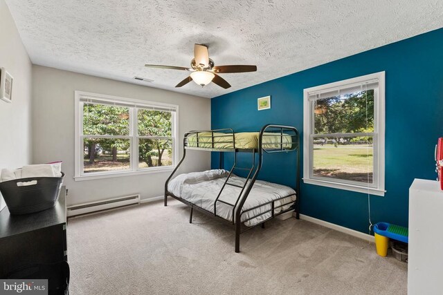 carpeted bedroom featuring a baseboard radiator, a textured ceiling, and ceiling fan