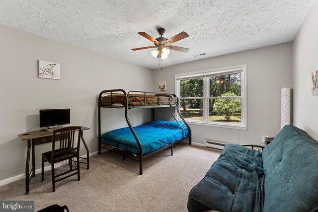 bedroom featuring a textured ceiling, light colored carpet, and ceiling fan