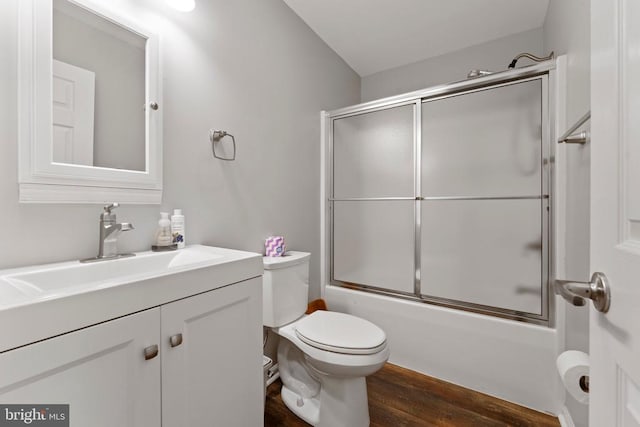 full bathroom with toilet, hardwood / wood-style floors, shower / bath combination with glass door, and vanity