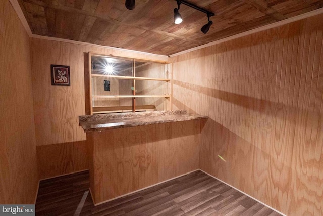 bar featuring wood walls, dark wood-type flooring, wooden ceiling, and track lighting