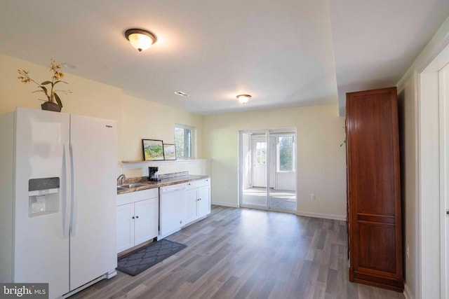 kitchen with white cabinets, wood-type flooring, white appliances, and sink