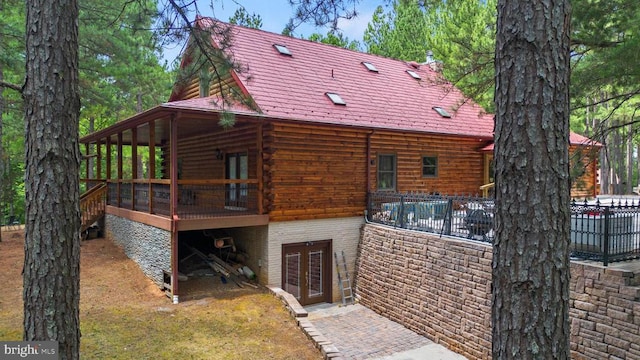 view of property exterior with a deck and french doors