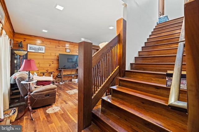 stairway featuring wood walls and hardwood / wood-style floors