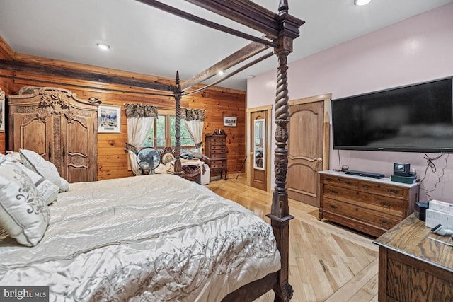 bedroom featuring beamed ceiling and wooden walls