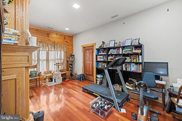 office area with wooden walls and wood-type flooring