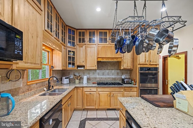 kitchen featuring black appliances, custom exhaust hood, decorative backsplash, sink, and light stone counters