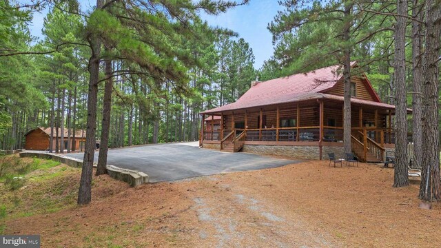 log-style house with a garage and a porch