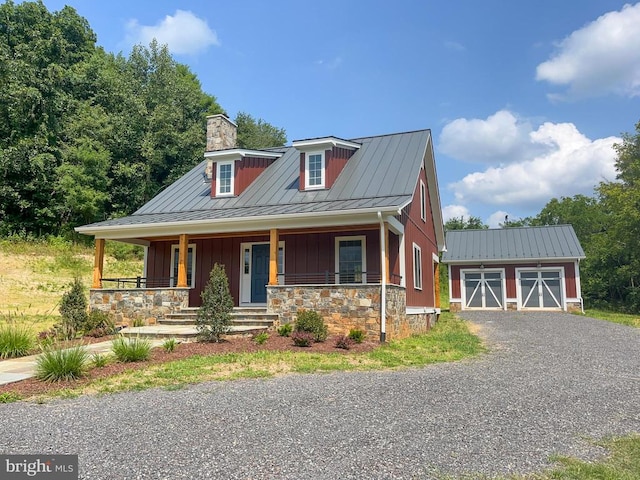 view of front of house featuring a garage, covered porch, and an outdoor structure