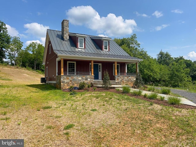 view of front of house featuring cooling unit, a front yard, and covered porch