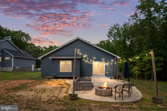 back house at dusk with a fire pit and a patio area