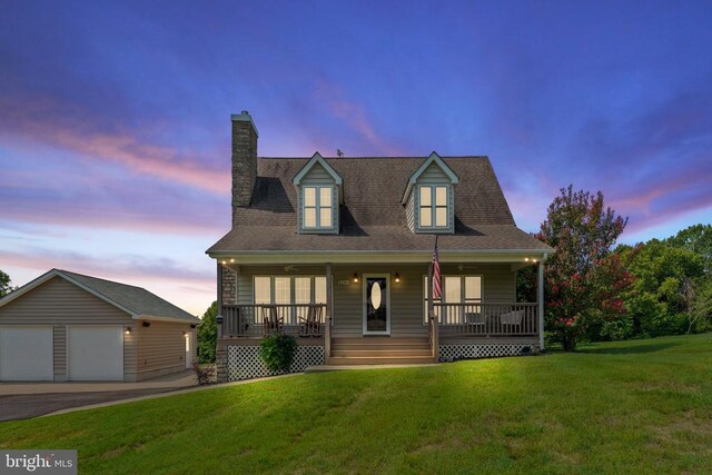 new england style home featuring a garage, a chimney, a porch, an outbuilding, and a front lawn