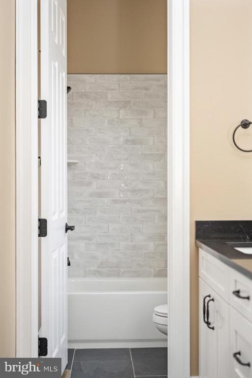 full bathroom with vanity, tiled shower / bath, tile patterned flooring, and toilet