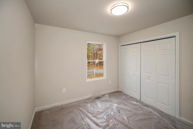 unfurnished bedroom featuring a closet and baseboards