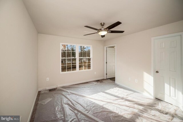 unfurnished bedroom with ceiling fan and baseboards