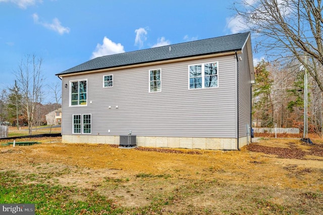 exterior space with a shingled roof, fence, and central air condition unit