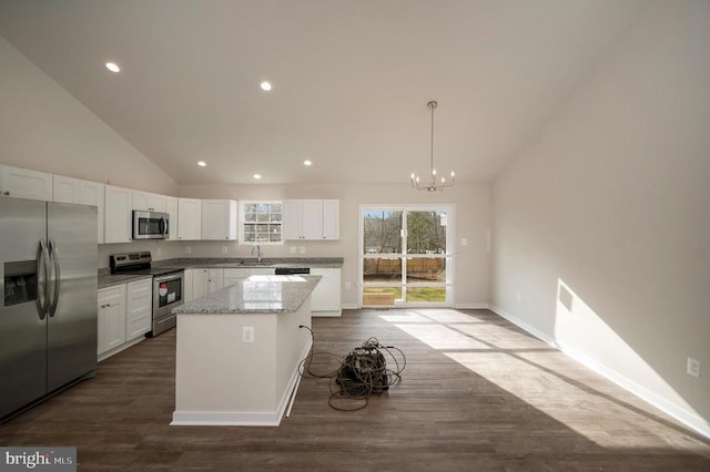 kitchen featuring dark wood-style floors, a kitchen island, appliances with stainless steel finishes, white cabinetry, and a sink