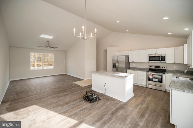 kitchen with appliances with stainless steel finishes, a sink, dark wood finished floors, and white cabinets