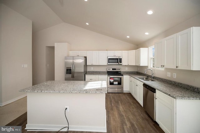 kitchen with appliances with stainless steel finishes, dark wood-style flooring, a center island, white cabinetry, and a sink