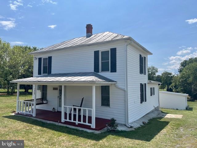 view of front of home featuring covered porch and a front lawn