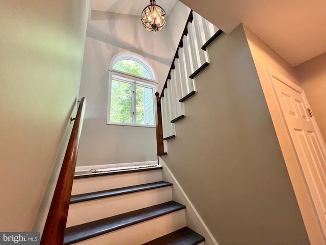 stairway featuring a chandelier