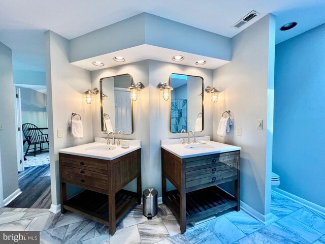 bathroom featuring hardwood / wood-style flooring, double vanity, and toilet