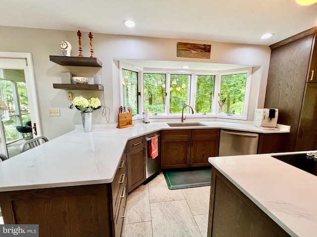 kitchen featuring dishwasher, light stone countertops, light tile patterned floors, sink, and kitchen peninsula