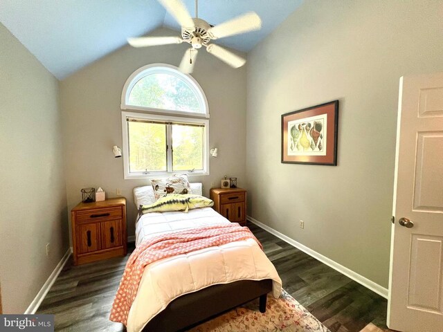 bedroom with ceiling fan, vaulted ceiling, and dark hardwood / wood-style floors