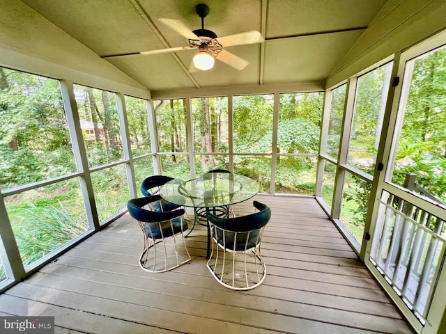 sunroom featuring ceiling fan, vaulted ceiling, and a healthy amount of sunlight