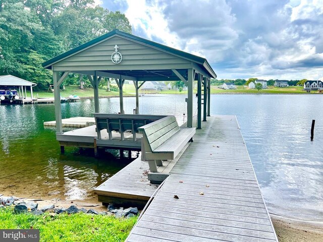 view of dock with a water view and a yard