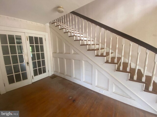 stairs featuring hardwood / wood-style flooring and french doors