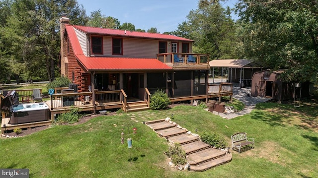 back of property featuring a yard, a sunroom, and a wooden deck