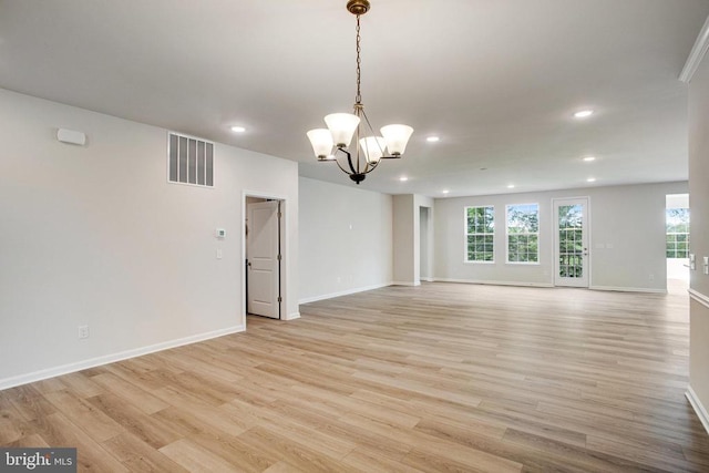 unfurnished living room with an inviting chandelier and light wood-type flooring