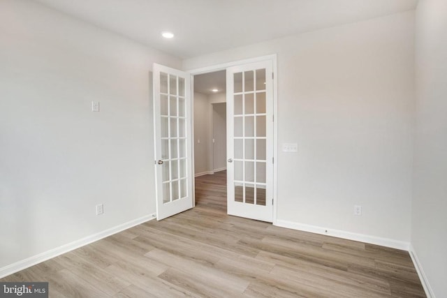 unfurnished room featuring french doors and light wood-type flooring