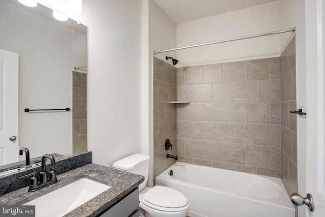 full bathroom featuring vanity, tiled shower / bath, and toilet