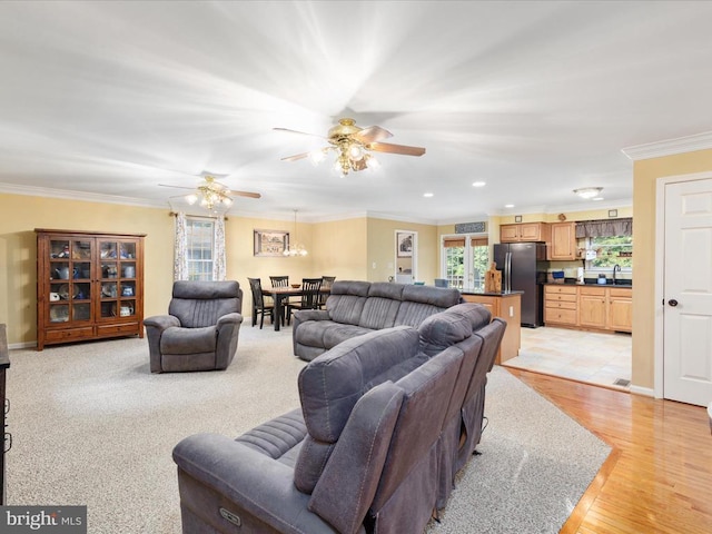 living room with plenty of natural light, ceiling fan, sink, and light hardwood / wood-style floors