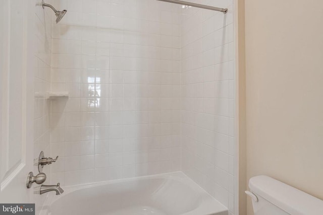 bathroom with tiled shower / bath combo and toilet