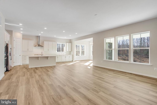 unfurnished living room with light wood-type flooring and sink