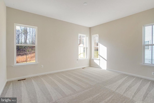 carpeted spare room featuring a wealth of natural light