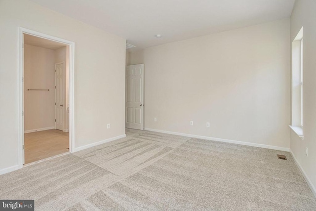 unfurnished room featuring light carpet