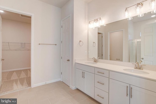 bathroom with tile patterned flooring, vanity, and a shower with shower door