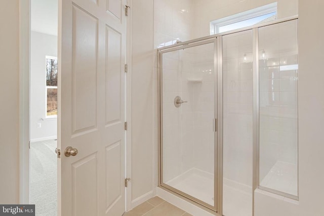 bathroom featuring tile patterned flooring, plenty of natural light, and walk in shower