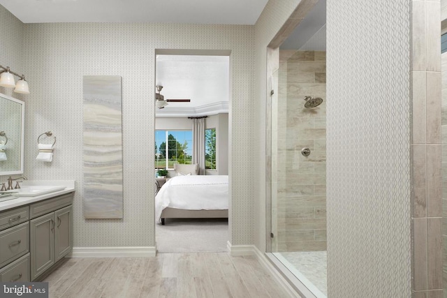 bathroom with hardwood / wood-style flooring, vanity, and tiled shower