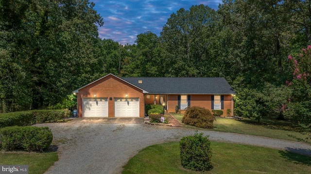 ranch-style house with a garage and a yard