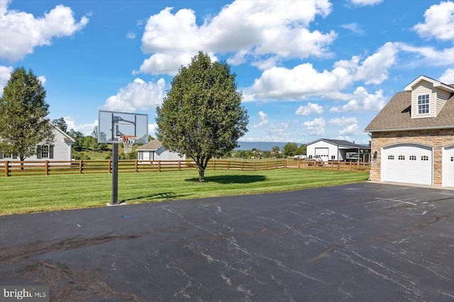 view of sport court with a yard and a rural view