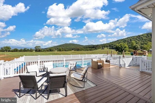 deck with a fenced in pool and a mountain view