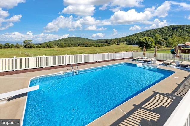 view of swimming pool featuring a diving board and a patio