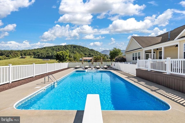 view of swimming pool with a diving board